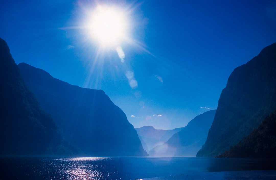 The sun shines brightly over a mountain range