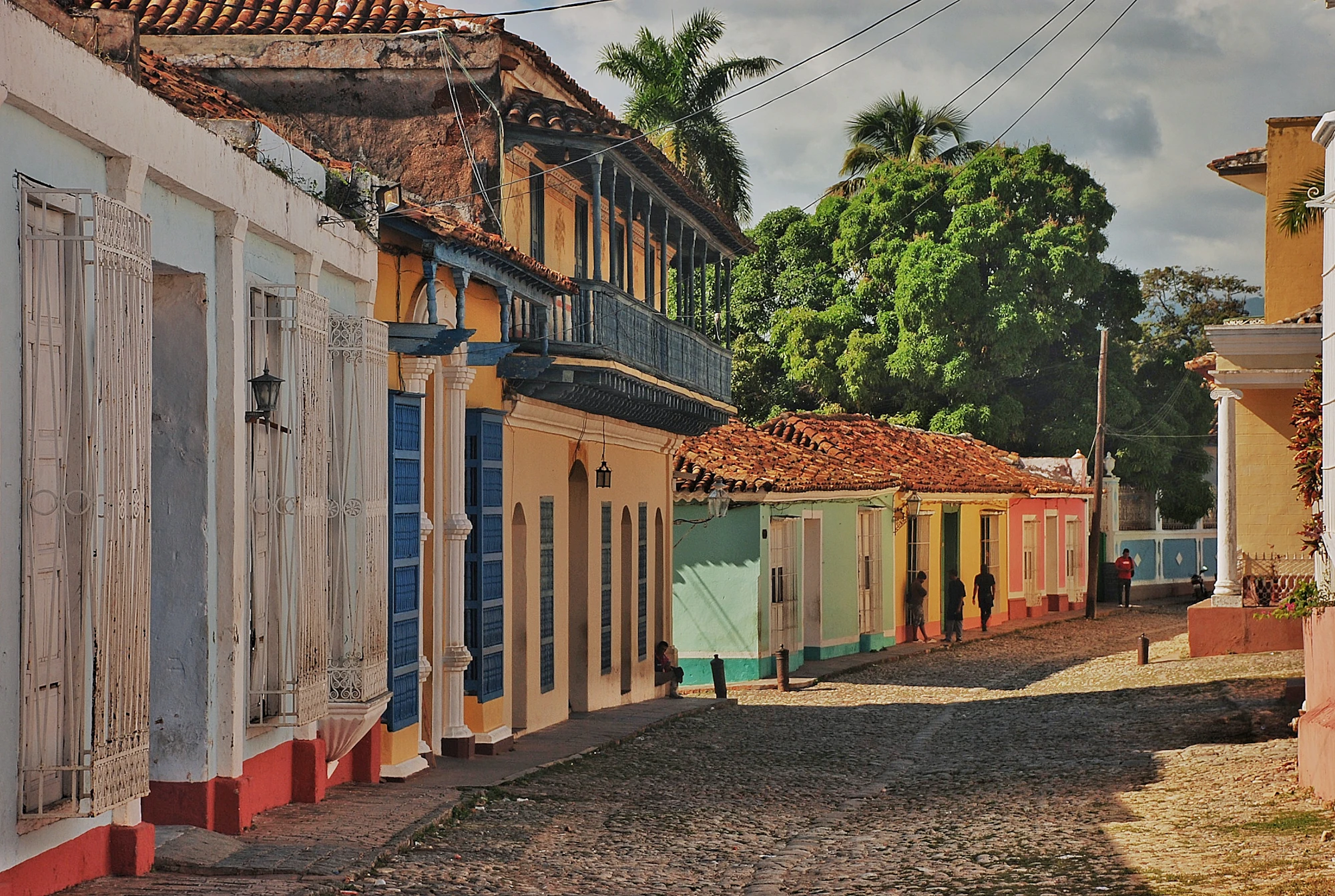 Colorful colonial buildings line a cobblestone street.