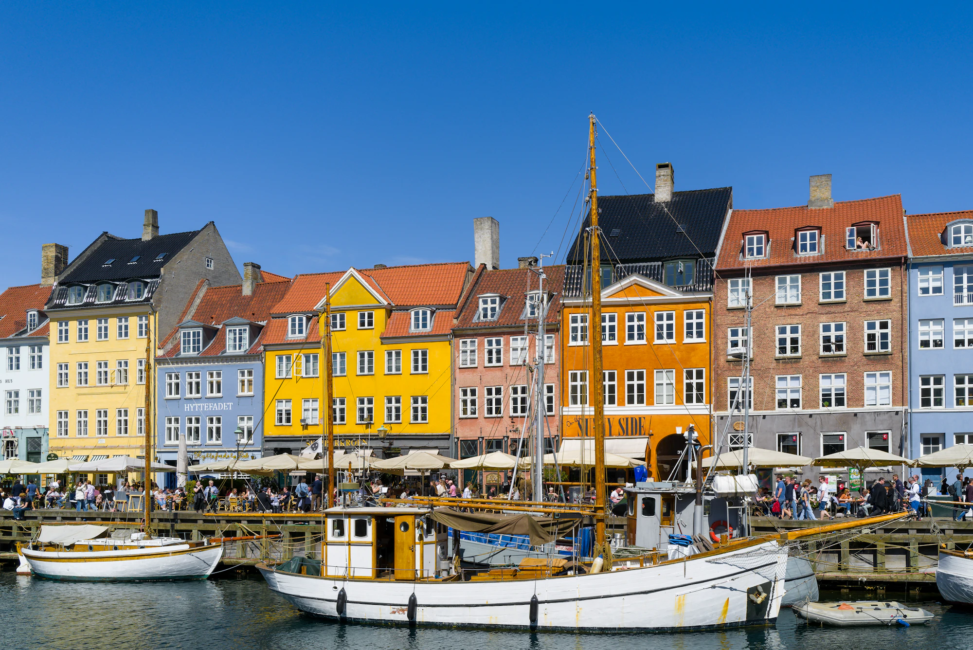 Colorful buildings line a harbor with boats.