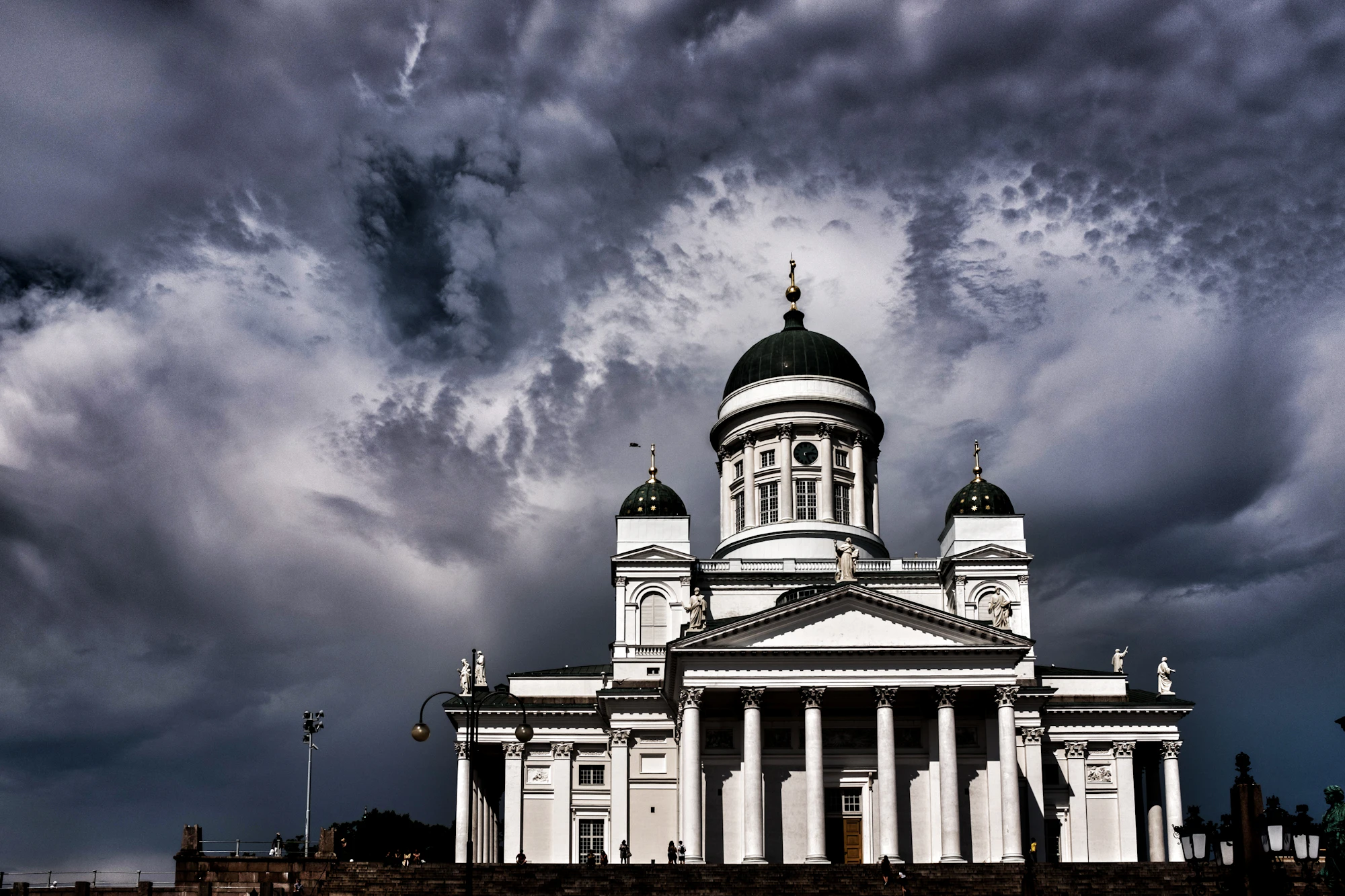 Helsinki cathedral stands majestic under a stormy sky.