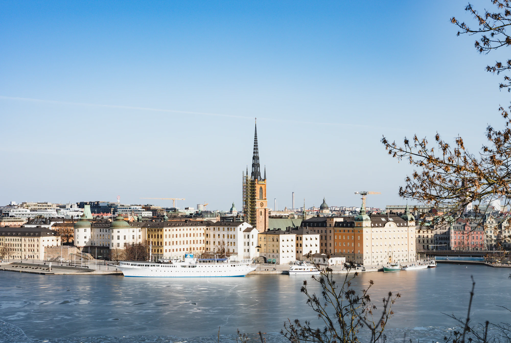 City skyline with church spire and waterfront buildings by water