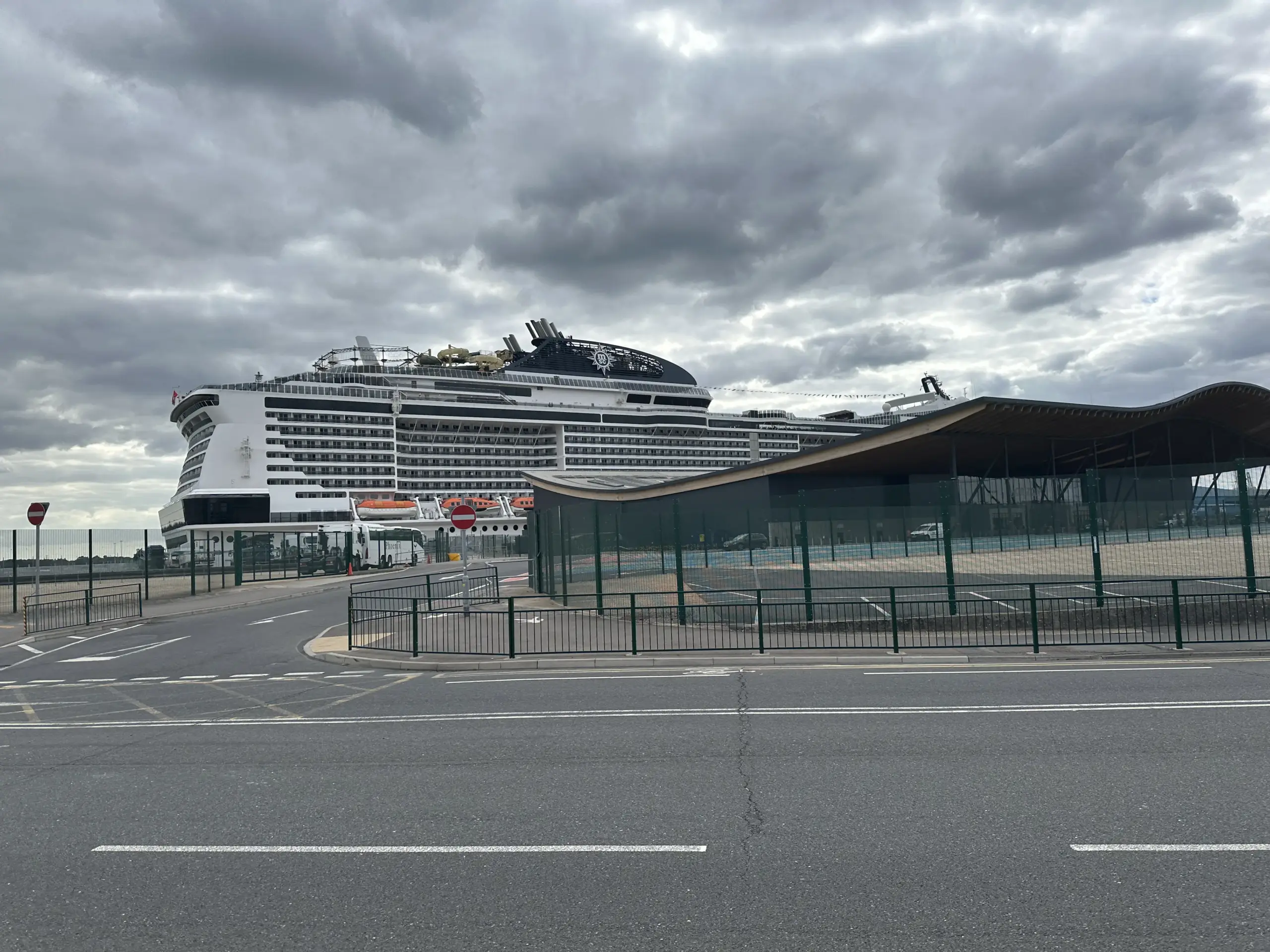 MSC Virtuosa berthed at Horizon Cruise Terminal in Southampton, with the terminal's distinctive curved timber canopy roof in view