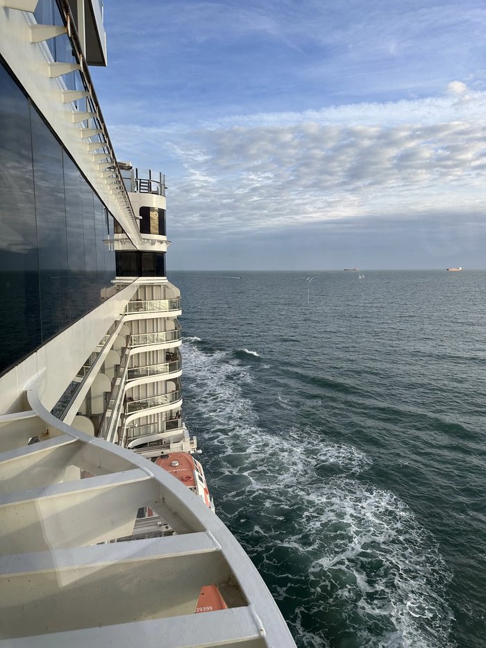 Looking down the length of a cruise ship to its wake at sea        
